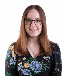 Person smiling in floral blouse, white background