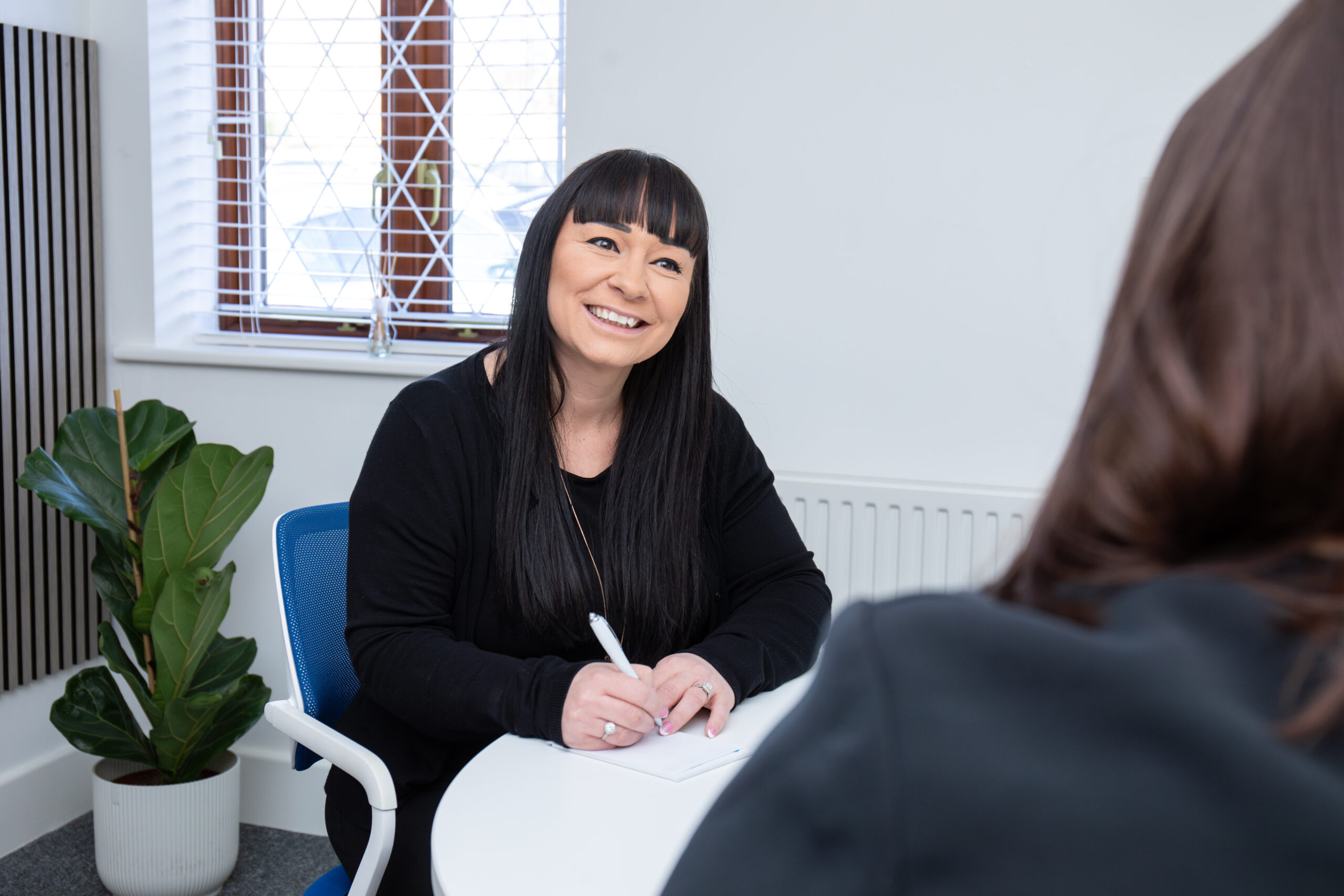 Smiling woman in office with colleague.